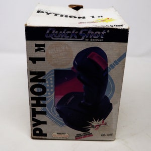 May include: A black and red Quick Shot Python 1M joystick for a computer. The box features the product name, Quick Shot by Bondwell, and the model number QS-137F. The joystick has a black base and a red button.
