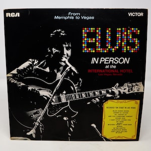Peut inclure: Une photo en noir et blanc d'Elvis Presley jouant de la guitare sur scène. Le texte "Elvis In Person at the International Hotel Las Vegas, Nevada" est imprimé sur la pochette de l'album. La pochette de l'album liste également les chansons enregistrées sur l'album.