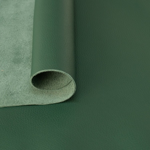 Puede incluir: Un rollo de cuero verde oscuro con una superficie lisa y texturizada.