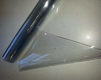 May include: Two clear plastic sheets, one rolled up and one flat. The rolled sheet has a slight sheen and the flat sheet is more translucent.
