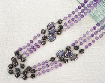 Stunning three strand purple bead statement necklace with purple and blue agate stones set in an antique black and crystal surround
