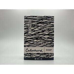 May include: A rectangular box of Cabochard soap. The box has a black and white abstract design. The brand name "GRES PARIS FRANCE" is printed on the upper left corner. The soap weighs 5 oz.