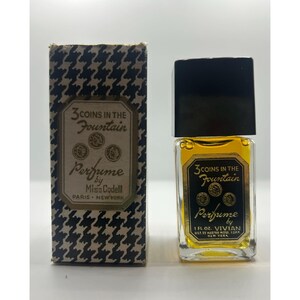 Puede incluir: Botella de perfume vintage y su caja. La botella es cuadrada con tapa negra y contiene líquido amarillo. La caja es de pata de gallo en blanco y negro con las palabras "3 COINS IN THE Fountain" y "Perfume by Miss Codell" impresas.