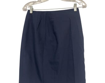 May include: A navy blue skirt hanging on a clear plastic hanger. The skirt is knee-length with a straight cut and a simple design. The fabric appears to be a smooth, solid material.