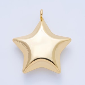 May include: A gold-colored star pendant with a loop at the top for hanging. The star has five points and a smooth, reflective surface. The pendant is likely made of metal and is suitable for jewelry making.