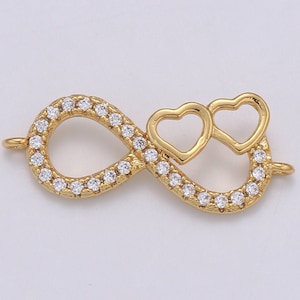 May include: Gold infinity charm with two interlocking hearts, accented with clear cubic zirconia stones.