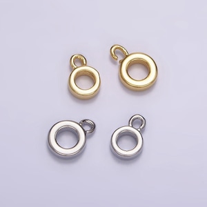 May include: Four metal jump rings with a loop on top. Two are gold and two are silver.