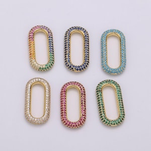 May include: Six gold oval-shaped connector charms with different colored cubic zirconia stones. The charms are set against a white background.