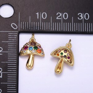 May include: Two gold-tone mushroom charms with colorful crystal accents. The charms are approximately 1 inch in size.