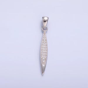May include: A silver pendant with a long, narrow, teardrop-shaped design. The pendant is set with small, clear cubic zirconia stones.
