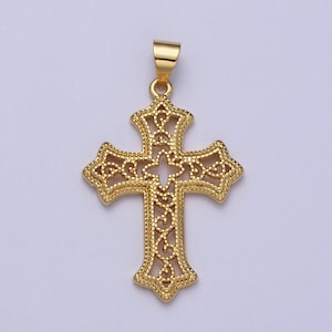 May include: A gold-toned filigree cross pendant with a detailed design. The cross is hollow and has a delicate, intricate pattern.