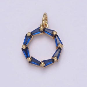 May include: Gold pendant charm with a circle of blue baguette-shaped crystals.