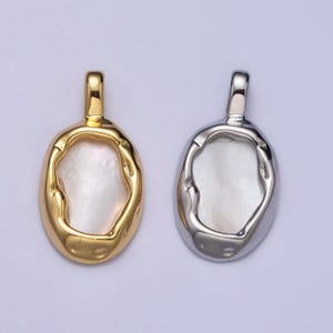 May include: Two oval-shaped pendants with a white mother-of-pearl inlay. One pendant is gold-toned and the other is silver-toned.
