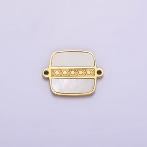 May include: A gold-toned square charm with a white mother-of-pearl inlay and a decorative band of gold circles.