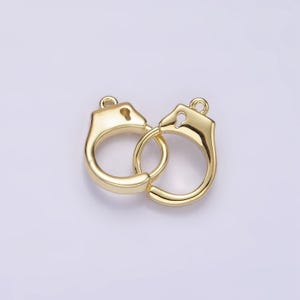May include: Gold-toned metal handcuff charm with a keyhole detail. The charm is designed to be used for jewelry making.