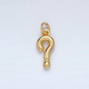 May include: A gold-colored question mark charm pendant. The charm is made of metal and has a smooth, shiny finish.