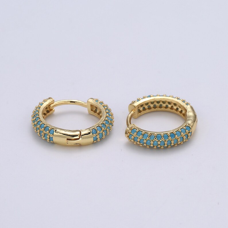 Pu&ograve; includere: Un paio di orecchini a cerchio color oro. Ogni orecchino &egrave; incastonato con piccole pietre color turchese. Gli orecchini hanno una chiusura a cerniera. Il design generale &egrave; elegante e adatto all'uso quotidiano o alle occasioni speciali.