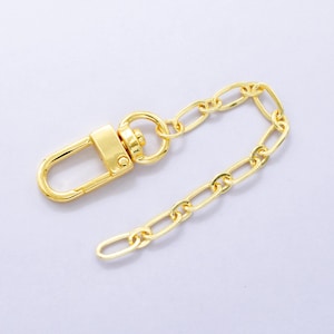 Puede incluir: Una cadena de metal dorado con un cierre de langosta. La cadena mide aproximadamente 25 cm de largo.