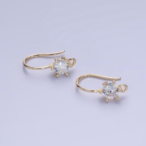 May include: A pair of gold-tone earring hooks with clear round cubic zirconia stones.