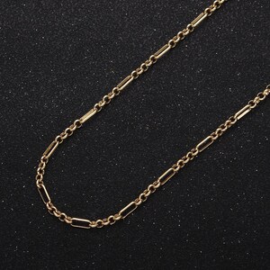 Puede incluir: Un collar de cadena de oro con un diseño de cadena de caja. La cadena está hecha de pequeños eslabones rectangulares.