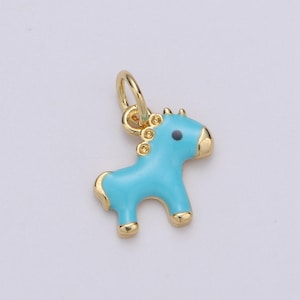 May include: A gold-colored charm in the shape of a blue horse. The horse has a black eye and a gold loop for attaching to a necklace or bracelet.