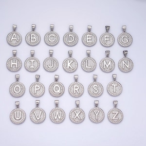 May include: A set of 26 silver pendants, each featuring a different letter of the alphabet, adorned with sparkling clear rhinestones.