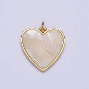 May include: A gold heart-shaped pendant with a white mother-of-pearl inlay.