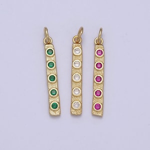 May include: Three gold bar pendants with different colored gemstones. The pendants have a textured surface and feature five round gemstones in a row. The gemstones are green, white, and pink.