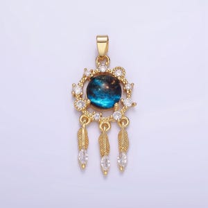 May include: Gold pendant necklace with a blue and black galaxy-like design surrounded by clear rhinestones and three gold feather charms.