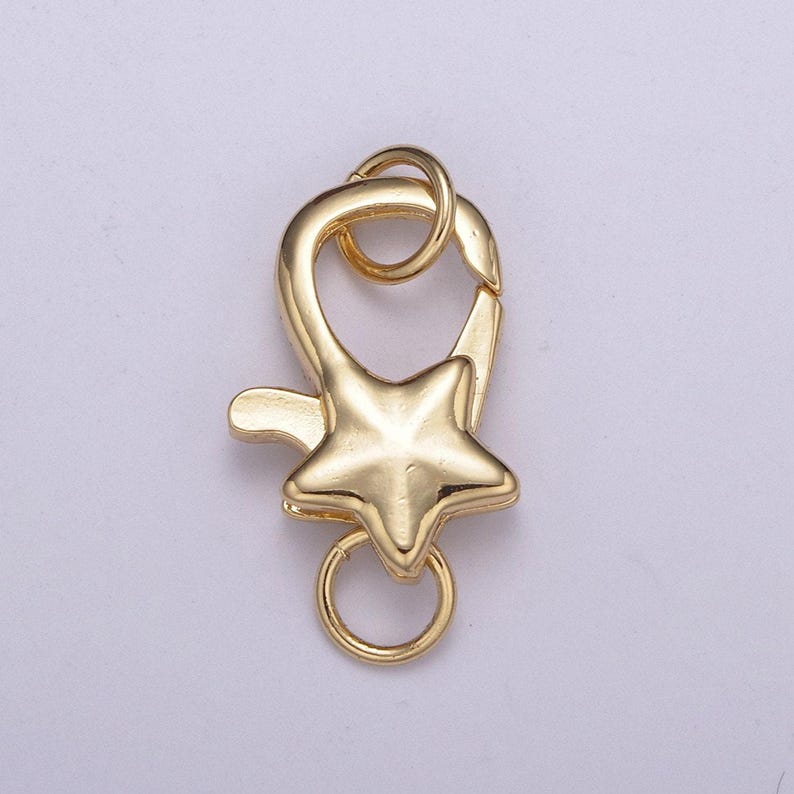 May include: Gold-toned metal star-shaped clasp with a ring for attaching to a necklace or bracelet.