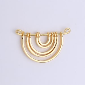 May include: Gold-toned metal pendant featuring four connected, semi-circular hoops. The pendant has a loop at the top for attaching to a chain.