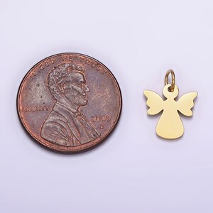 May include: A gold-colored angel charm pendant with a simple design. The charm is about the size of a US penny.
