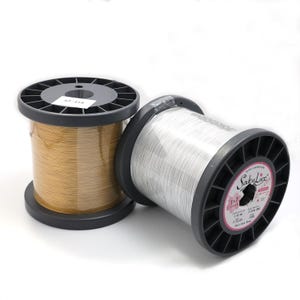 May include: Two spools of wire, one gold and one silver, on a white background. The silver spool has a label that reads "SakuLux".