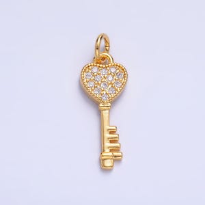 May include: A gold-tone key charm with a heart-shaped head encrusted with clear cubic zirconia stones.