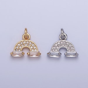 May include: Two rainbow charm pendants, one gold and one silver, with clear crystal accents.