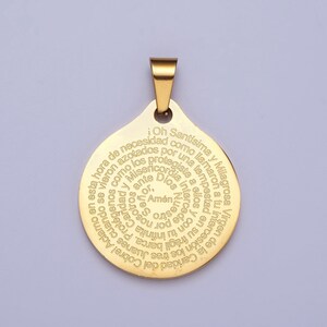 Pu&ograve; includere: Un ciondolo dorato con un ciondolo circolare che presenta un'iscrizione a spirale in spagnolo. L'iscrizione recita: "Oh Sant&iacute;sima y Milagrosa Virgen de la Caridad del Cobre! Aclamo en esta hora de necesidad como azotados por una tempestad vieron los tres Juanes cuando fr&aacute;gil barca. Protegiendolos infinita Caridad y Misericordia intercede por nosotros. Amen."
