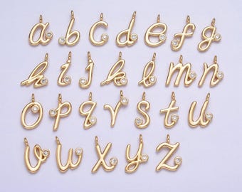 May include: A set of 26 gold-tone alphabet charms with a single clear rhinestone on each charm. The charms are in a cursive font.