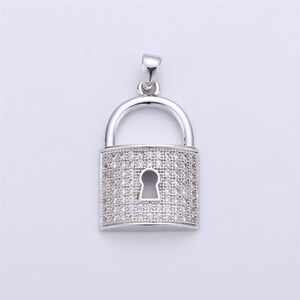 Pu&ograve; includere: Un ciondolo a forma di lucchetto in argento con un design in cristallo trasparente. Il lucchetto ha un buco della serratura ed &egrave; un gioiello popolare.