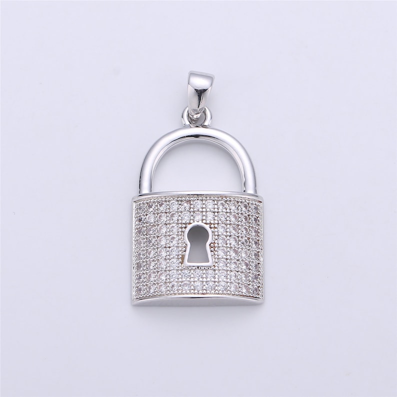 Pu&ograve; includere: Un ciondolo a forma di lucchetto in argento con un design in cristallo trasparente. Il lucchetto ha un buco della serratura ed &egrave; un gioiello popolare.