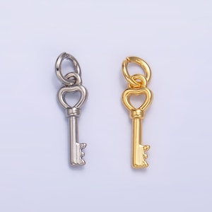 May include: Two key charms, one silver and one gold, each featuring a heart-shaped top and a key-shaped bottom. Ideal for jewellery making or crafting projects.