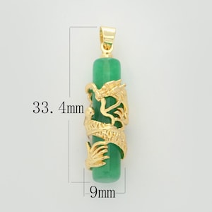 Op de afbeelding: Een gouden hanger met een groene jade-steen en een gedetailleerd drakenontwerp. De hanger is 33,4 mm lang en 9 mm breed.