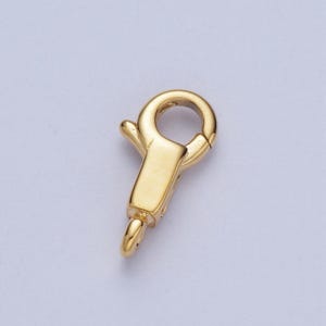 May include: Gold-toned metal clasp with a spring-loaded closure. The clasp is designed for attaching to jewellery chains or necklaces.
