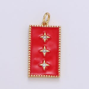 May include: A gold pendant with a red enamel rectangle featuring three gold stars with clear rhinestones. The pendant has a gold border with a repeating pattern.