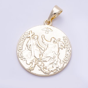 May include: A circular gold-toned pendant featuring a raised relief design of three figures and a dove. The text "S. TRINITAS" and "VNVS DEVS" is embossed along the curved edges. The pendant includes a polished gold-toned bail at the top.