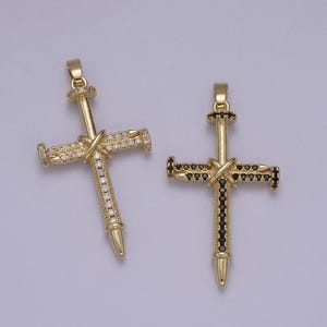 May include: Two gold-tone cross pendants with a nail design. One pendant is adorned with clear rhinestones, while the other is adorned with black rhinestones.