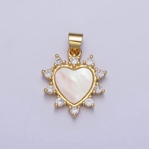 May include: A gold heart-shaped pendant with a white mother-of-pearl inlay and a halo of clear cubic zirconia stones.