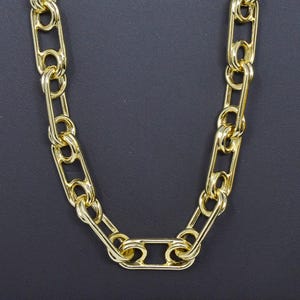 May include: A gold chain necklace with a link design. The chain is made of thick, oval-shaped links.