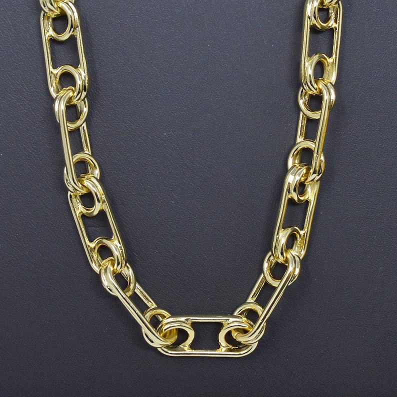 May include: A gold chain necklace with a link design. The chain is made of thick, oval-shaped links.