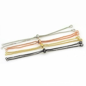 May include: Five adjustable bracelet cords with silver, rose gold, gold, and black chain links. Each cord has a small round bead and two clear crystal beads at the ends.