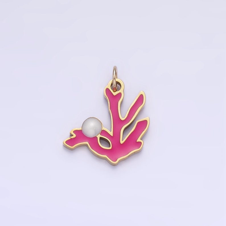 Op de afbeelding: Een gouden hanger met een roze koraaltak en een witte parel accent. De hanger is een delicaat en vrouwelijk sieraad.